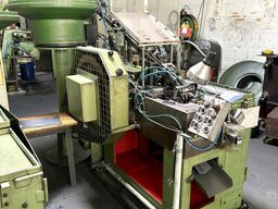 Cold heading machine including vibrating feeder
