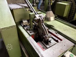 Cold heading machine including vibrating feeder