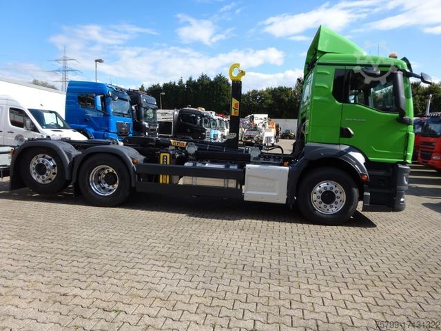 รถบรรทุกขนถ่ายตู้คอนเทนเนอร์แบบตะขอ (roll-off) MAN MAN 26.520 TGS HYVA Abroller 6x2 NEU